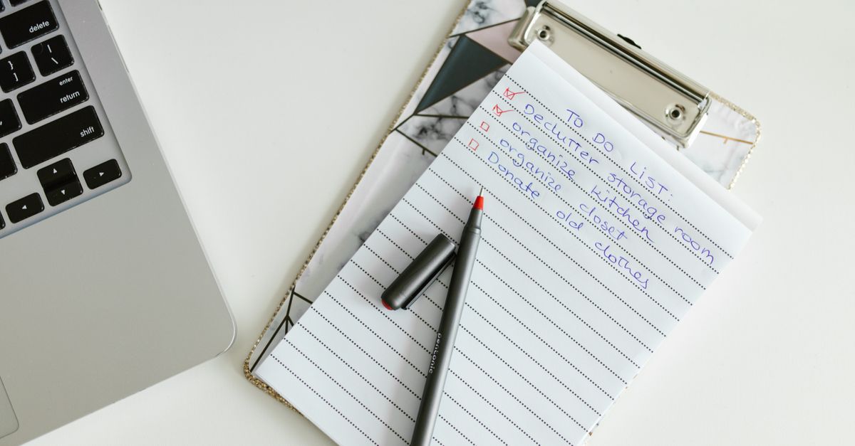 Organized to-do list on clipboard next to laptop