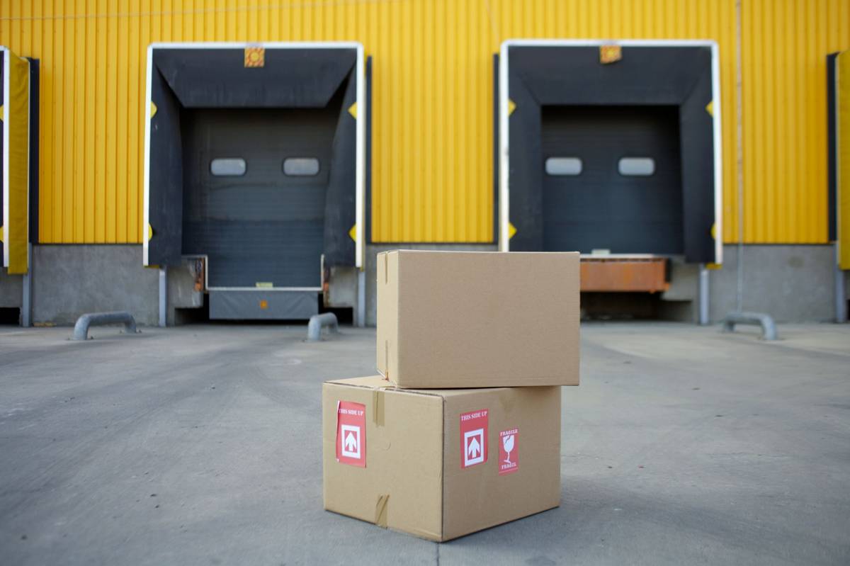 Cardboard cartons stacked in front of warehouse loading dock doors